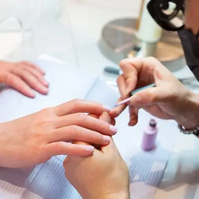 Purlux esthetician providing manicure service to happy client
