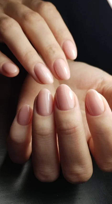 Des mains féminines avec des ongles manucurés en rose, illustrant l'élégance et le soin des manucures.