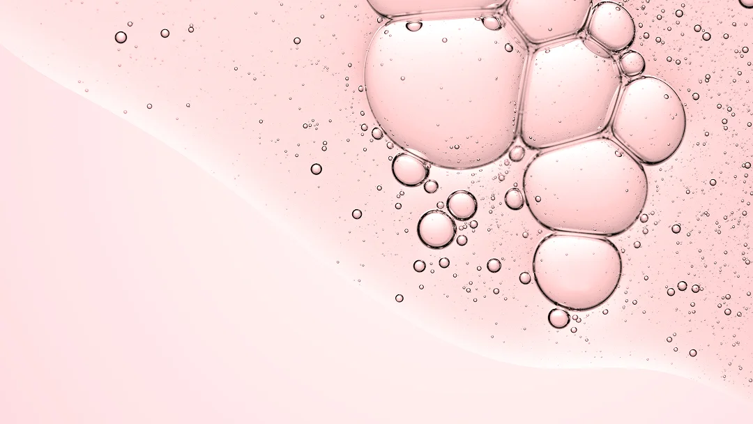 Bubbles d'eau sur un fond rose, illustrant un traitement laser non ablatif.